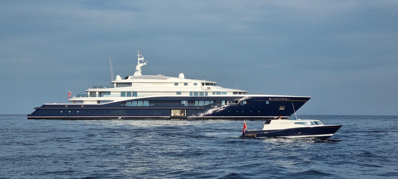 a large boat next to a smaller boat in the water aboard CARINTHIA VII Yacht for Sale