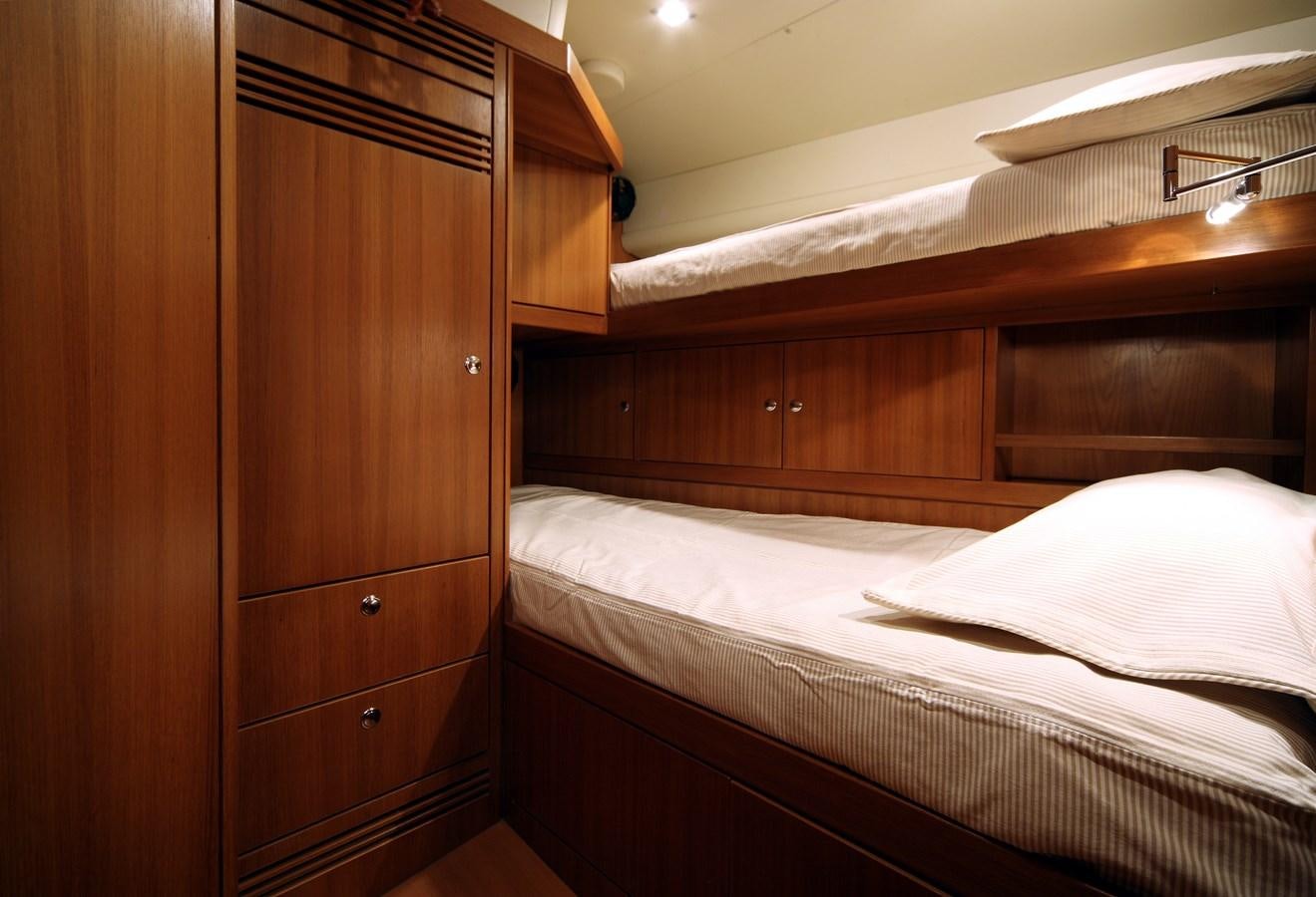 a bed with a wooden headboard aboard ACAIA Yacht for Charter