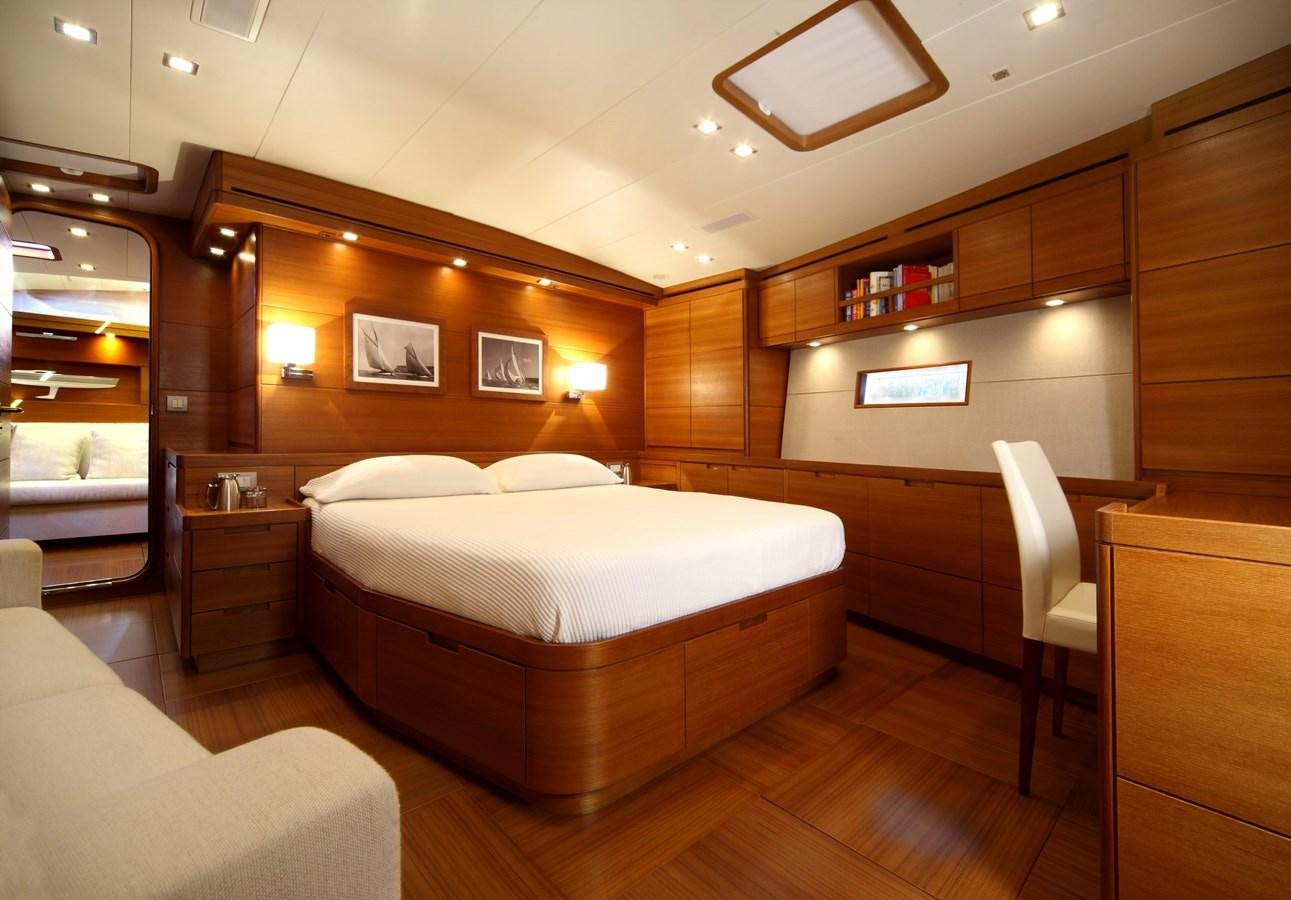 a room with a bed and a chair aboard ACAIA Yacht for Charter