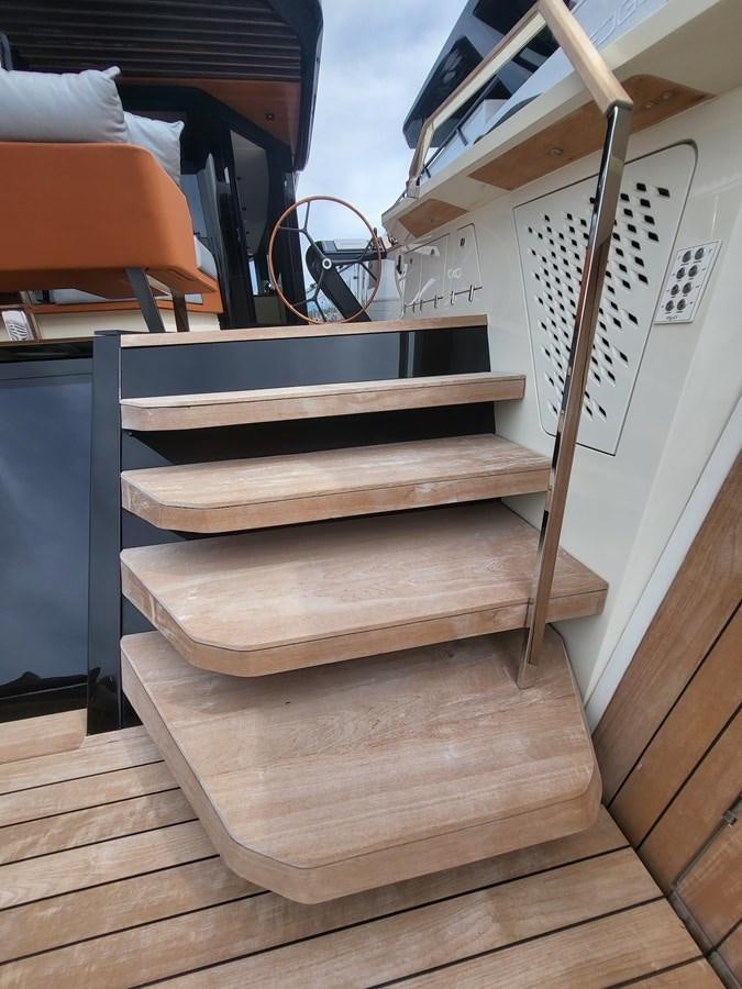 a wooden staircase with a metal railing aboard EVO V8  Yacht for Sale