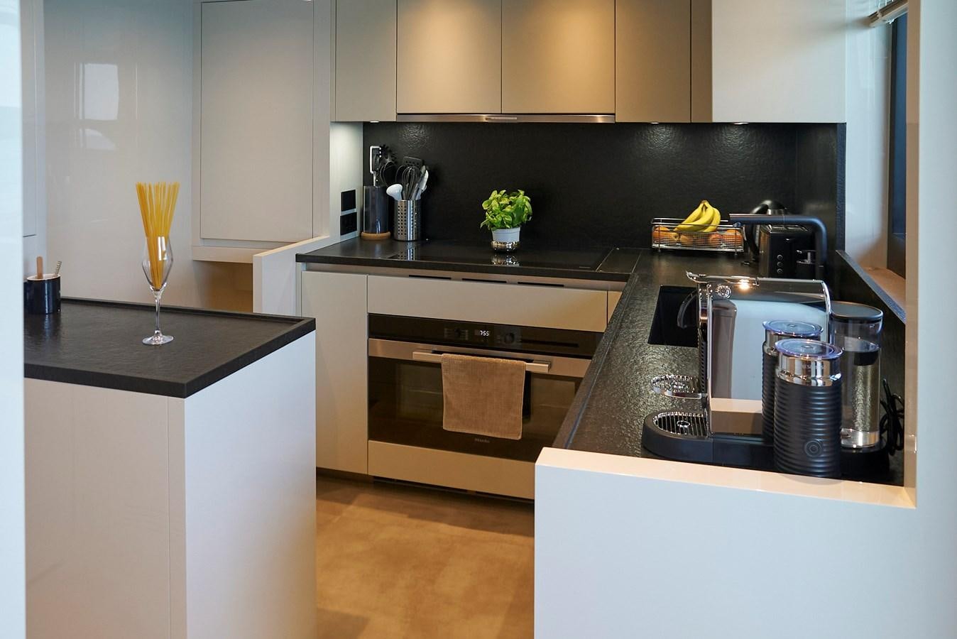 a kitchen with black appliances aboard SL96A Yacht for Sale