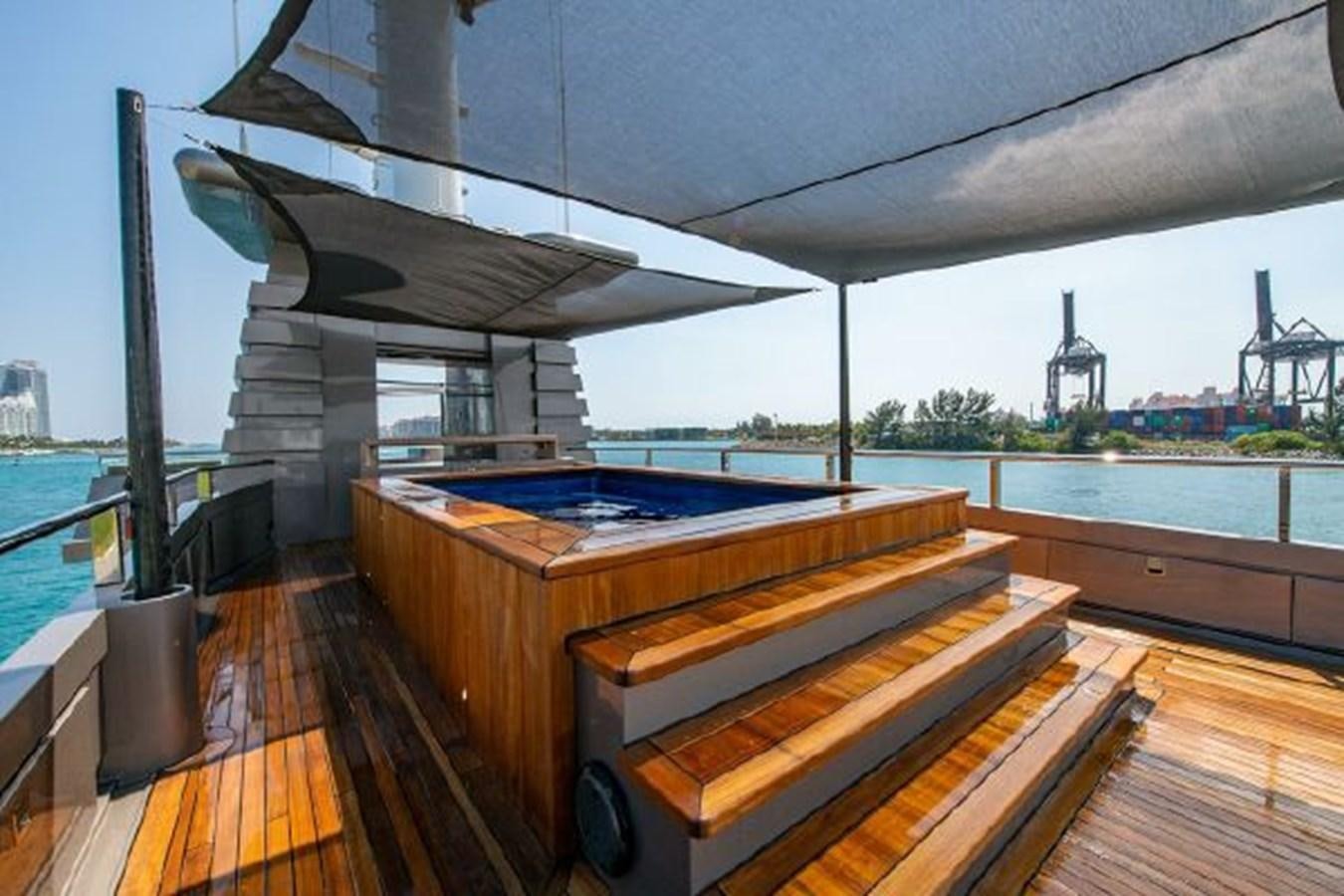 a deck with a large pool and a large building in the background aboard 174 OCEANFAST MOTOR YACHT Yacht for Sale