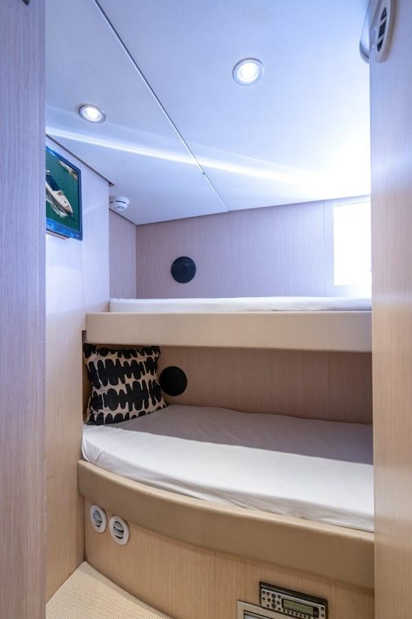 a room with a bed and a television on the wall aboard NAMEDROPPER Yacht for Sale
