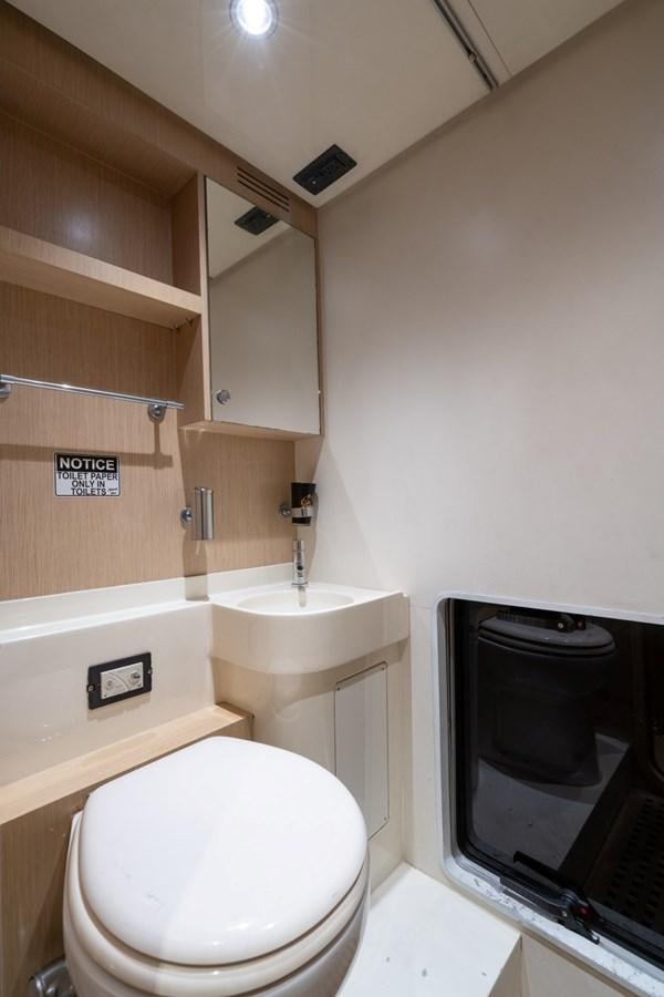 a bathroom with a television and a toilet aboard NAMEDROPPER Yacht for Sale