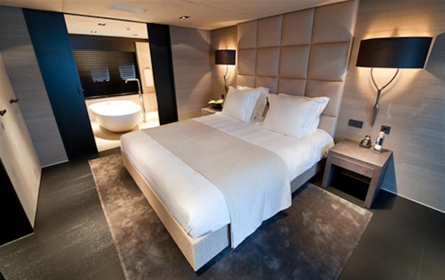 a hotel room with a bed and a lamp aboard LATITUDE Yacht for Charter