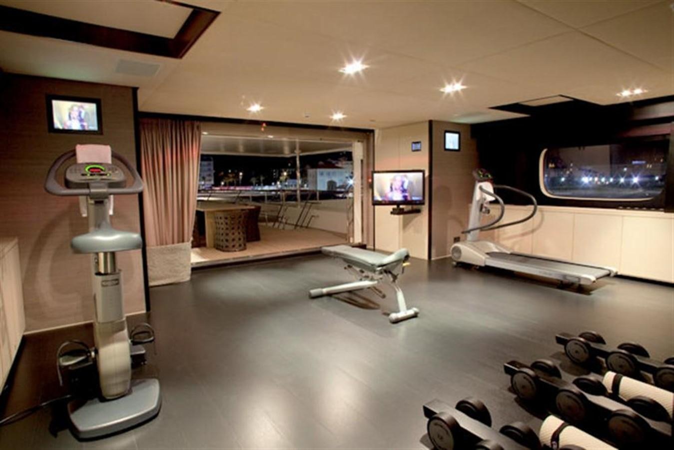 a room with a large mirror and a table with exercise equipment aboard LATITUDE Yacht for Charter