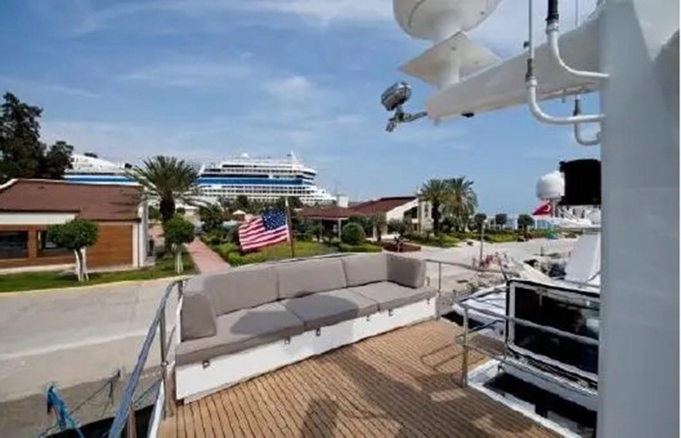 a deck with a flag and buildings in the background aboard GRAND AZURE  Yacht for Sale