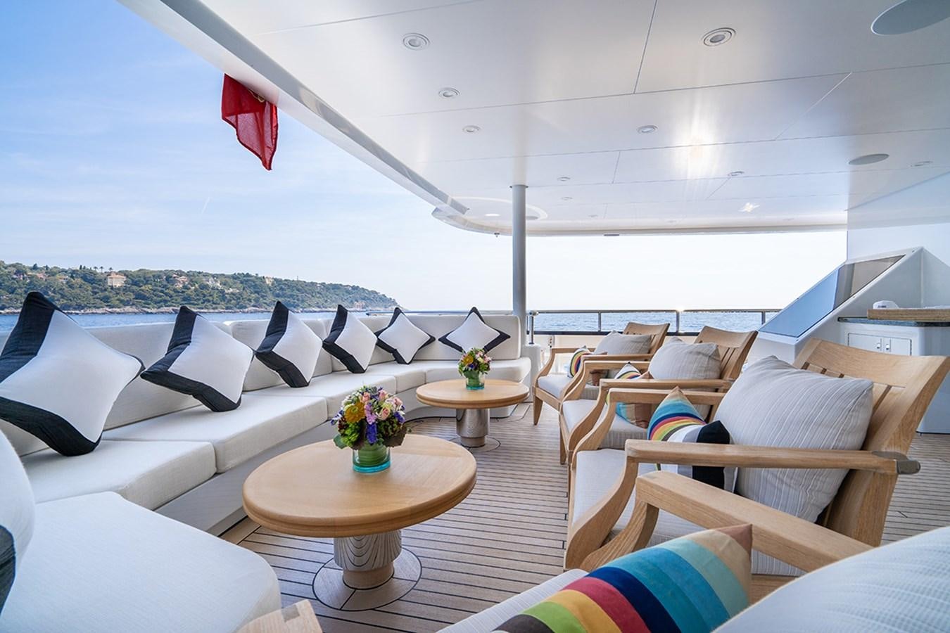 a room with a couch and a table with chairs and a window aboard KAISER Yacht for Sale