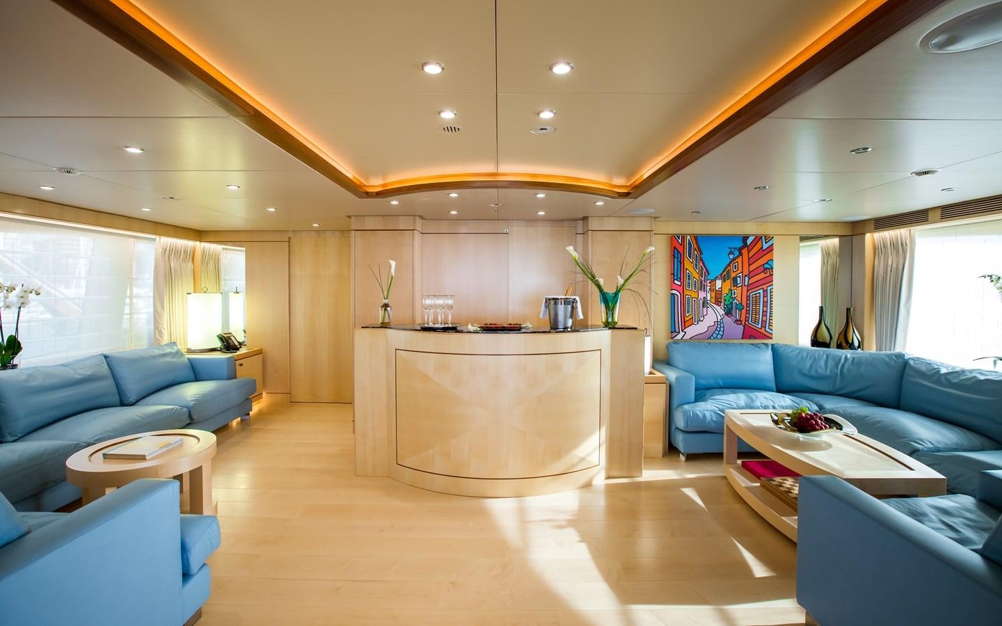 a large living room with a large table and couches aboard BLUE VISION Yacht for Charter