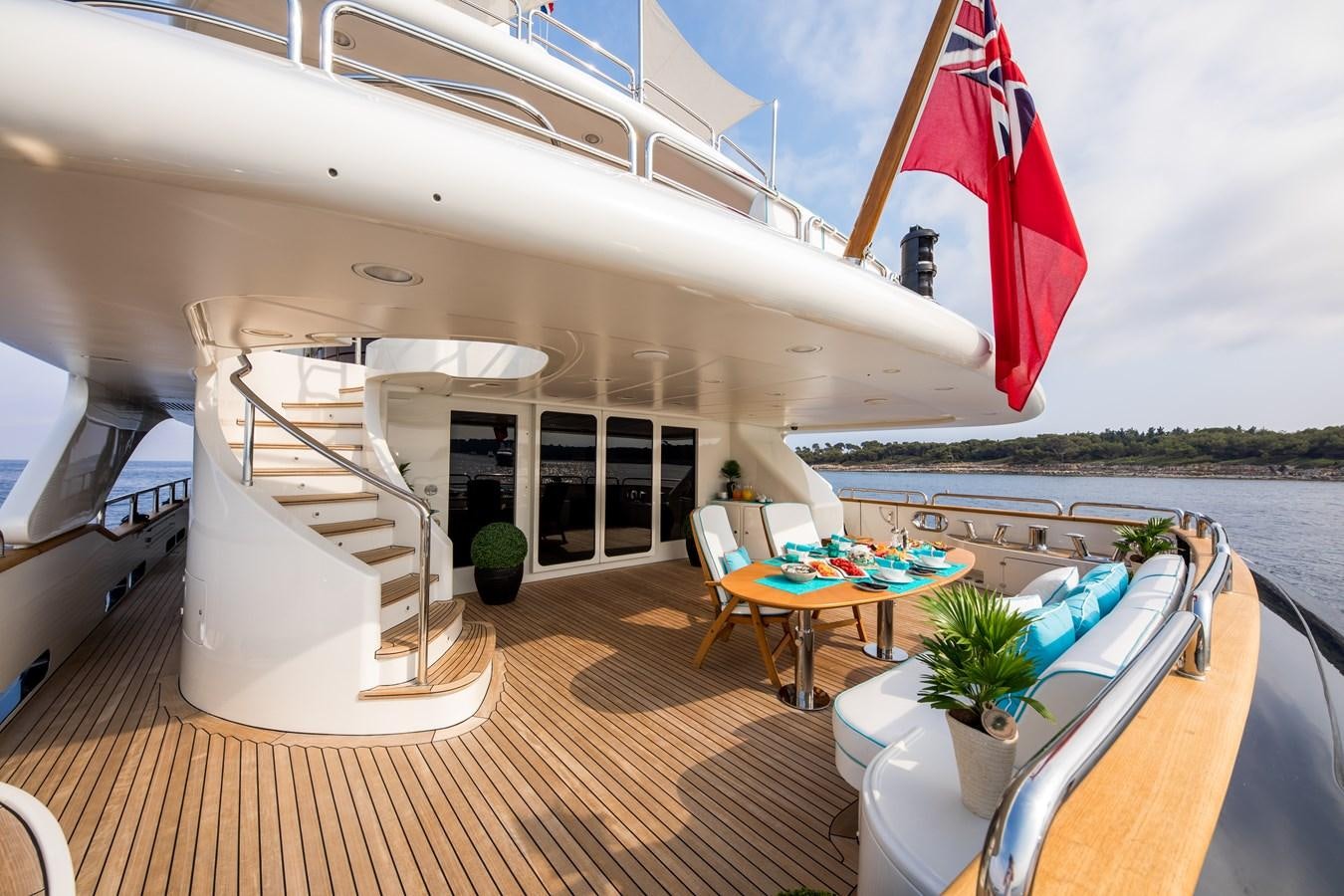 a large white boat with a flag on the deck aboard BLUE VISION Yacht for Charter