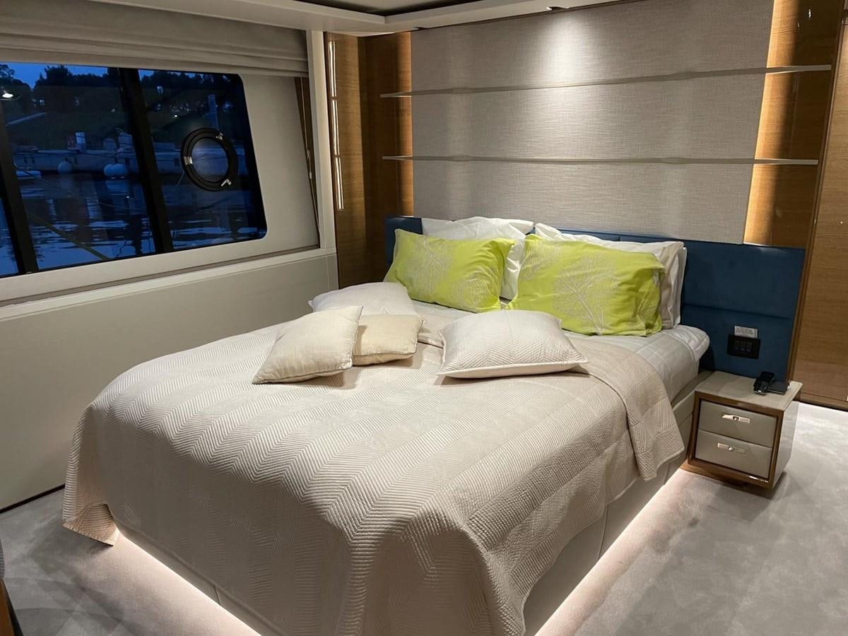 a bed with a white sheet and green pillows aboard AFON Yacht for Sale