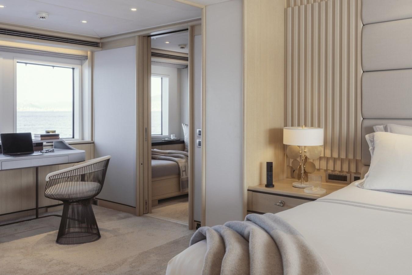 a bedroom with a bed and desk aboard LUCKY US Yacht for Sale