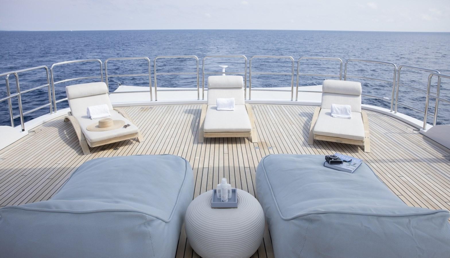 a deck with chairs and a table on it aboard LUCKY US Yacht for Sale