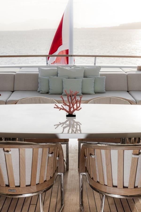 a table with chairs and a red flag on it aboard LUCKY US Yacht for Sale