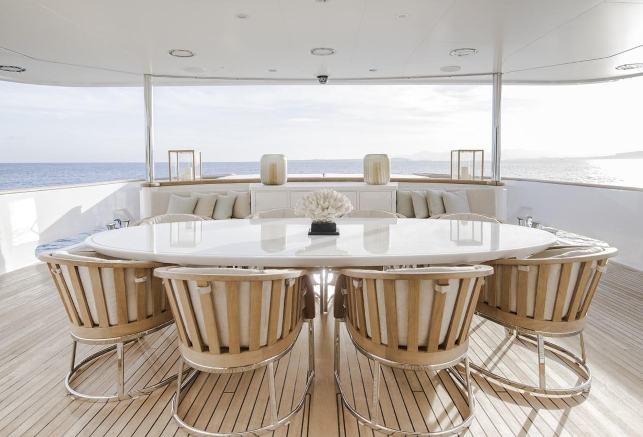 a table with chairs and a large white table with chairs on it aboard LUCKY US Yacht for Sale