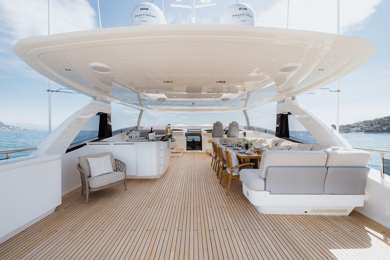 a large white yacht with chairs and tables on a deck aboard RIVIERA LIVING Yacht for Sale