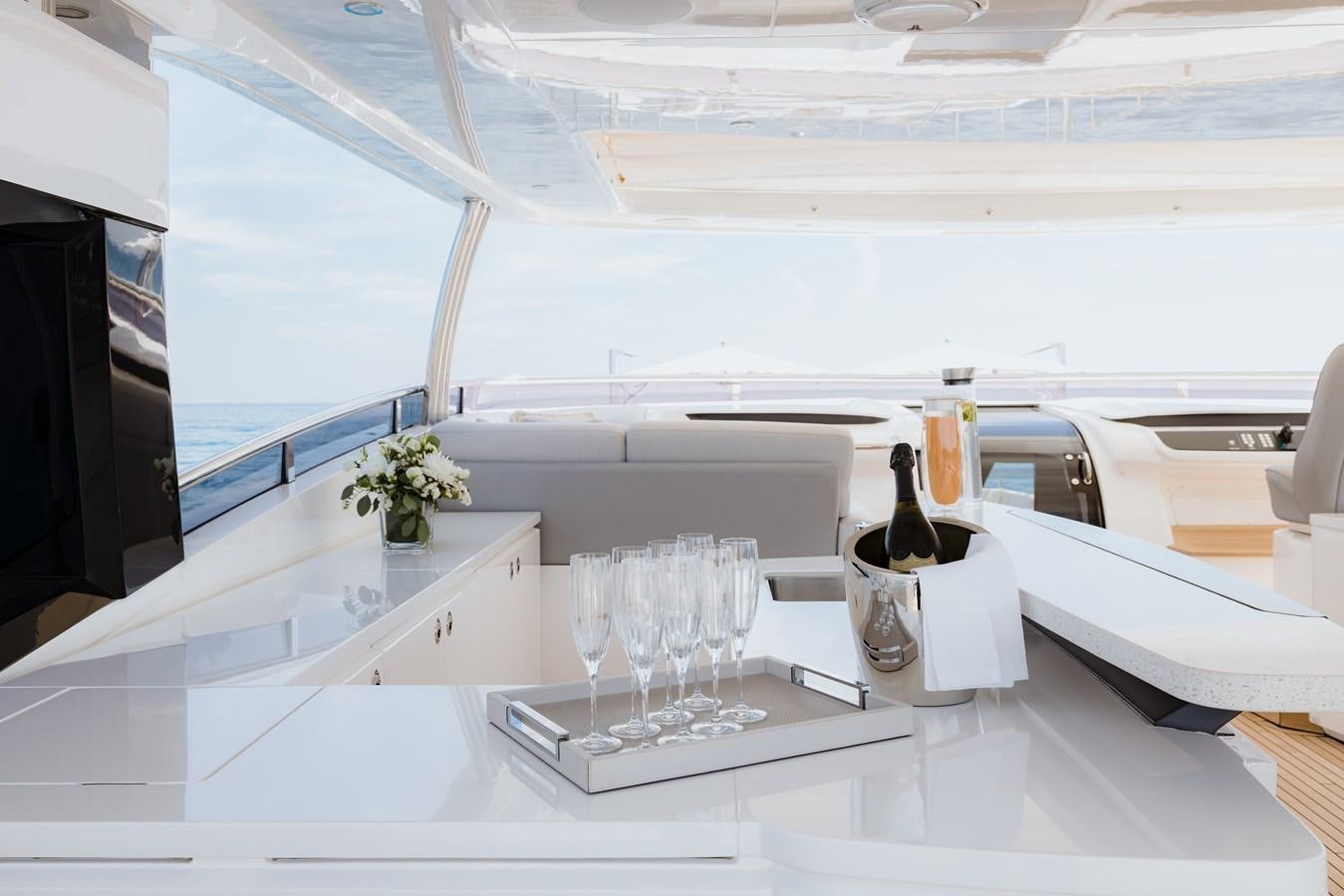a wine bottle and glasses on a counter aboard RIVIERA LIVING Yacht for Sale
