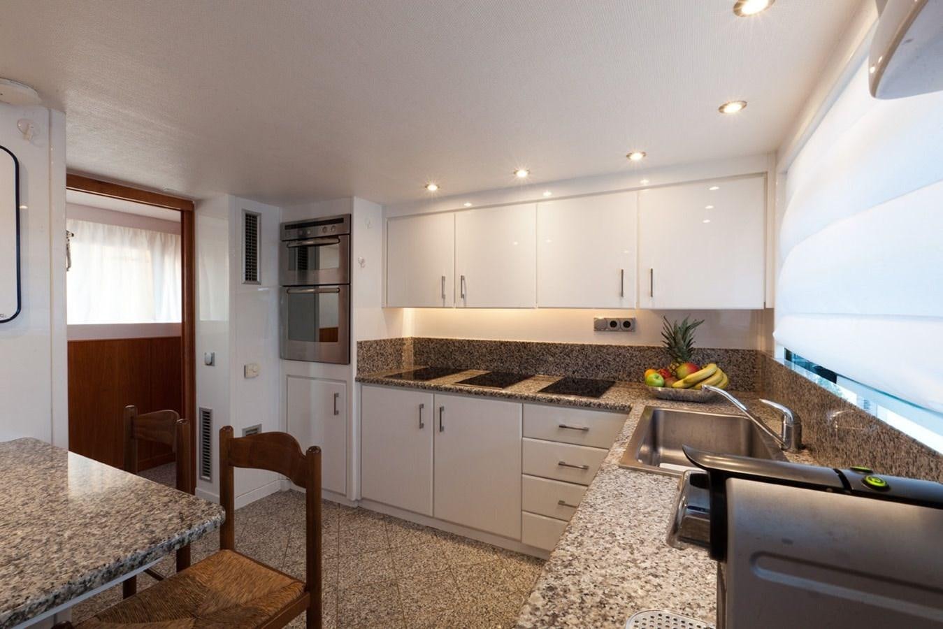 a kitchen with white cabinets aboard DUNE Yacht for Sale