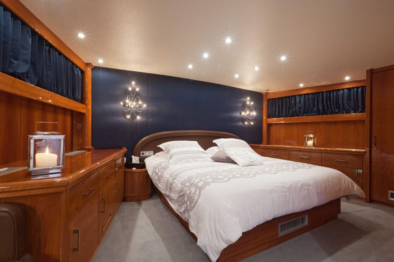 a bedroom with a bed and a dresser aboard DUNE Yacht for Sale