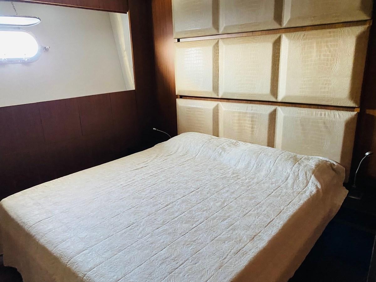 a bed with a wooden headboard aboard GINEVRA Yacht for Sale