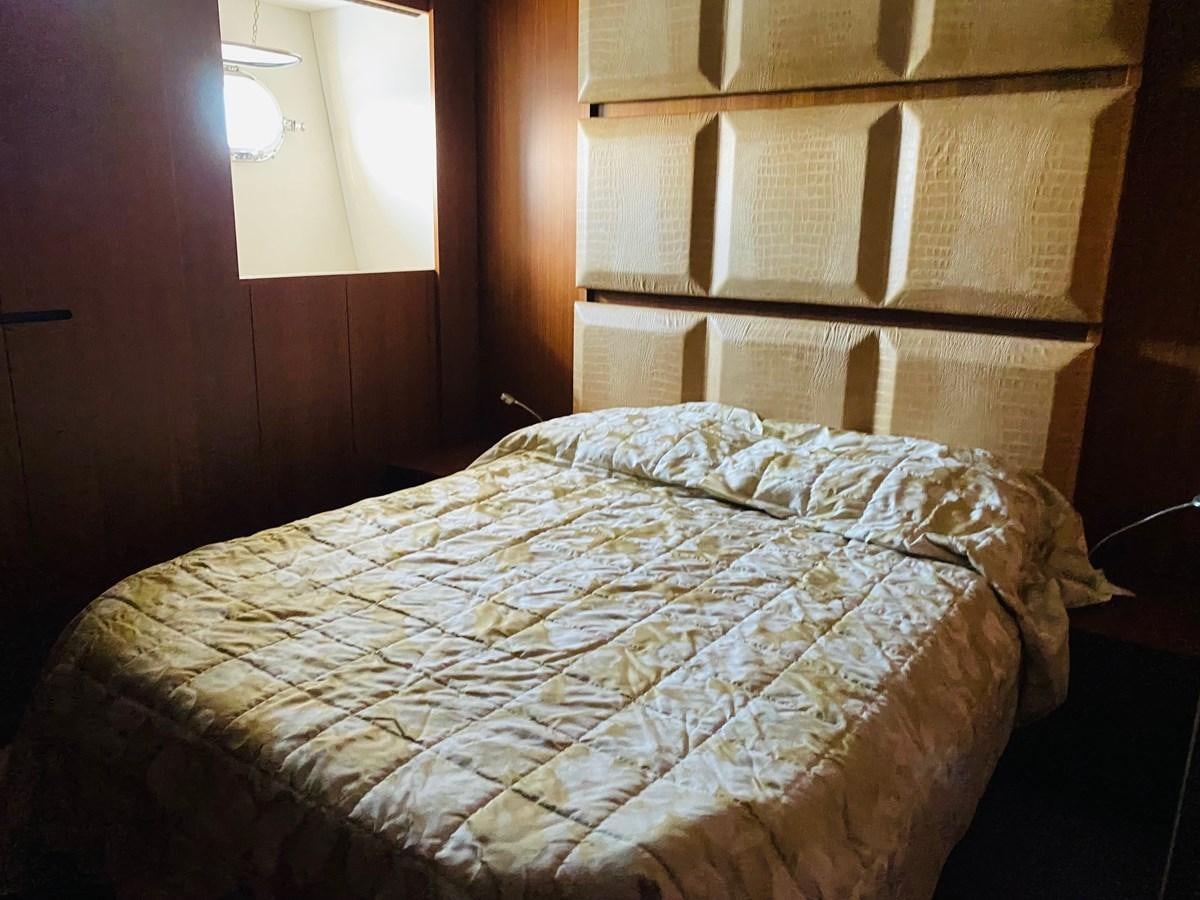 a bed with a wooden headboard aboard GINEVRA Yacht for Sale