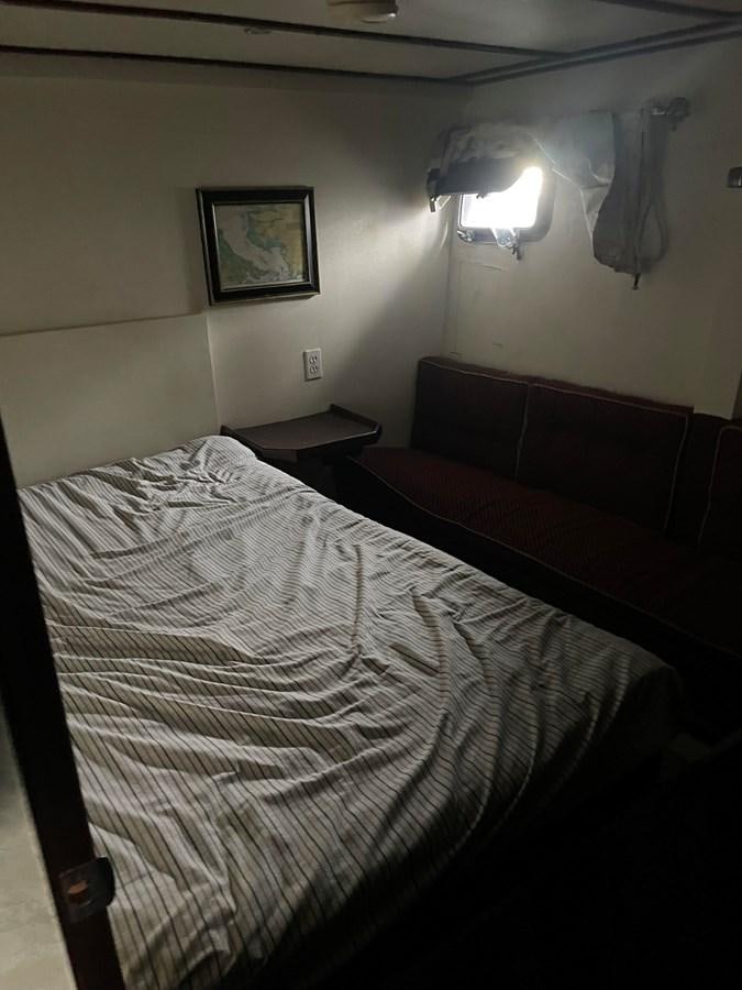 a bed with a white sheet and a red bed spread aboard MAGIC MOMENT Yacht for Sale