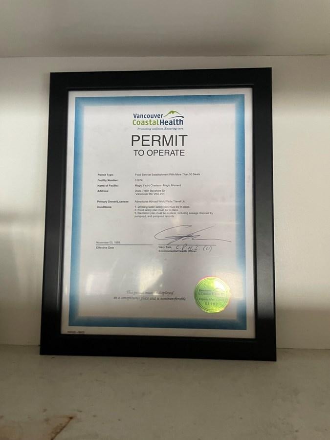 a black rectangular sign with text aboard MAGIC MOMENT Yacht for Sale