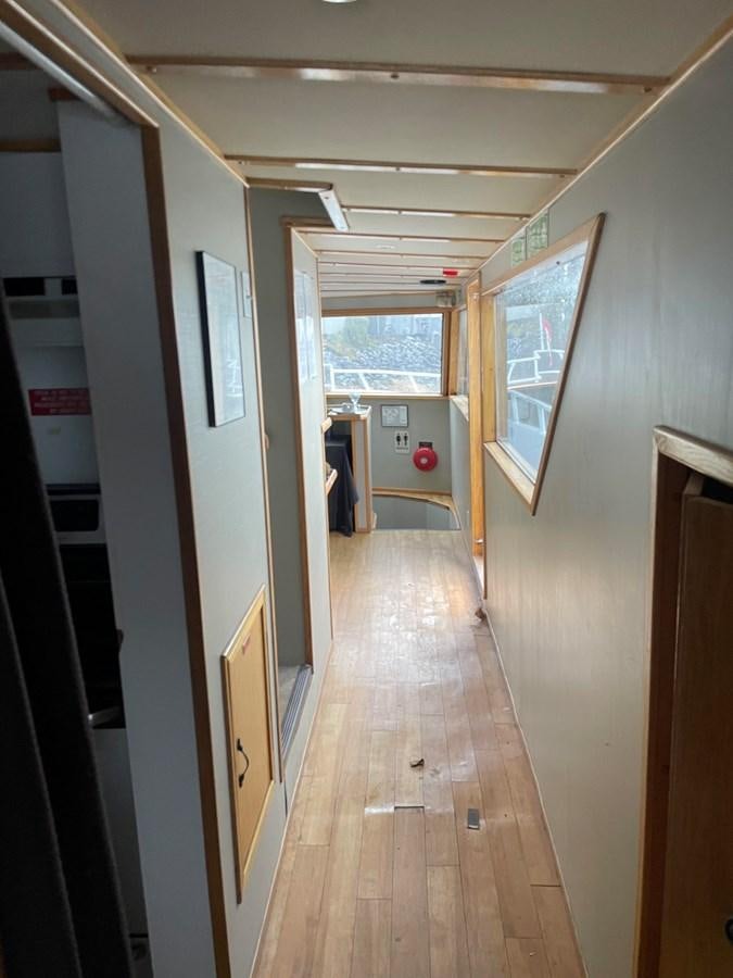 a hallway with a window and a door aboard MAGIC MOMENT Yacht for Sale