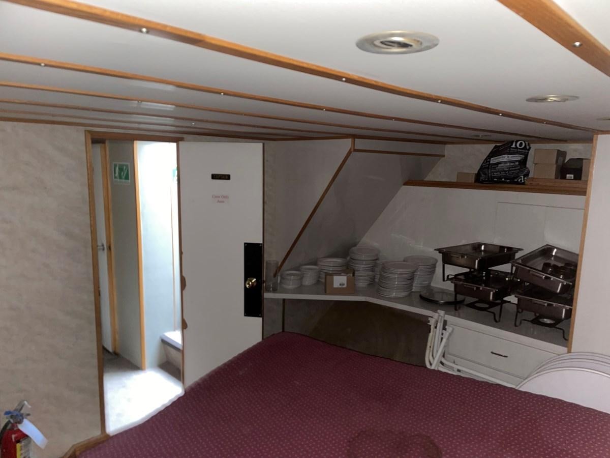 a kitchen with a bed and a pink sheet aboard MAGIC MOMENT Yacht for Sale