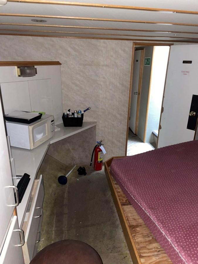 a room with a bed and a desk aboard MAGIC MOMENT Yacht for Sale