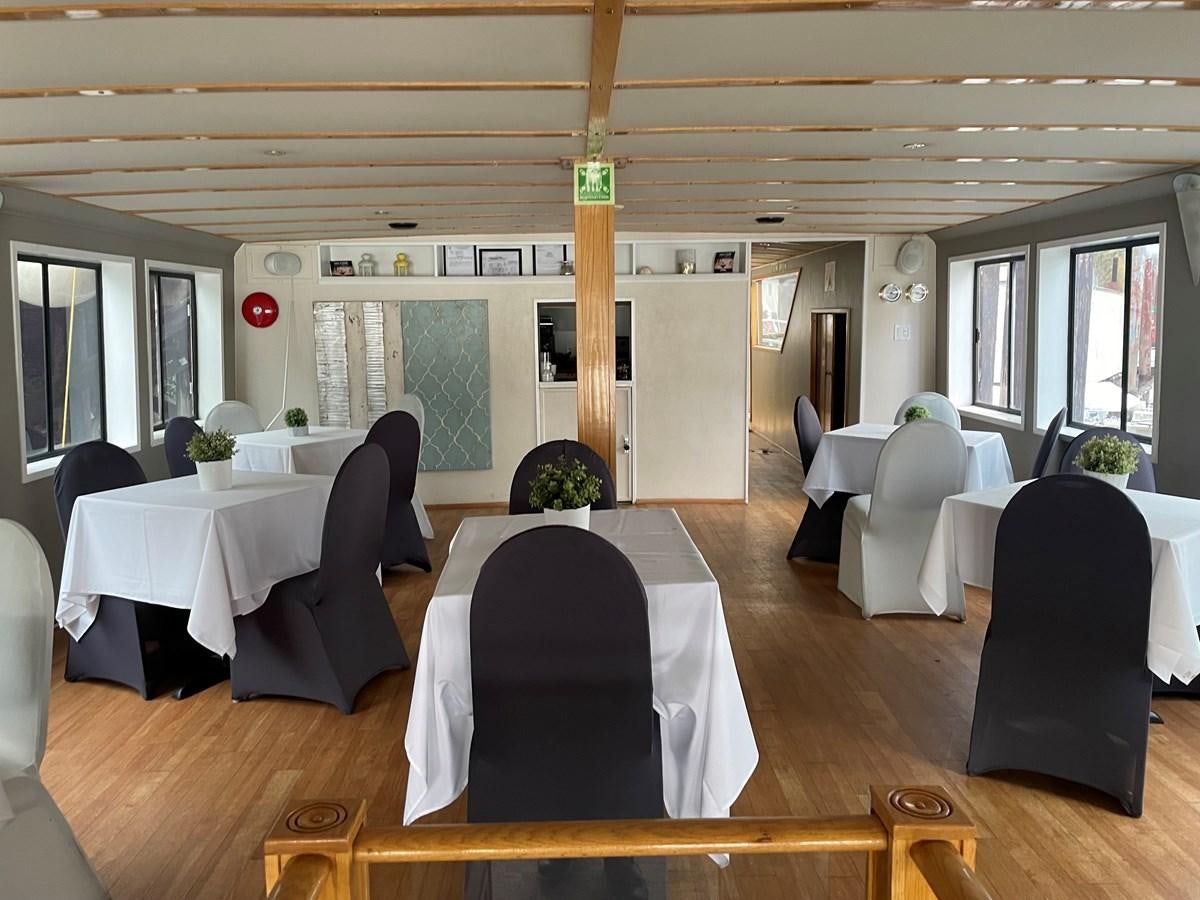 a room with tables and chairs aboard MAGIC MOMENT Yacht for Sale