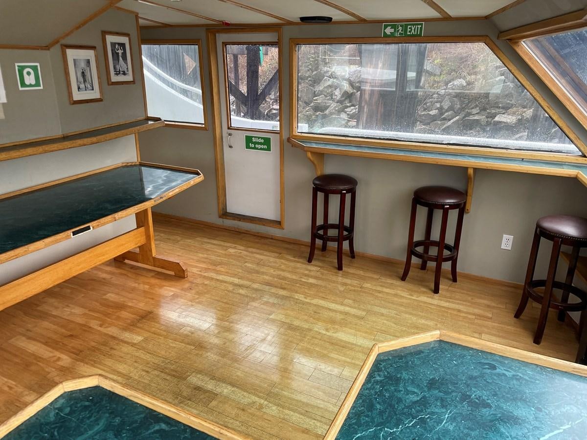 a room with a bench and stools aboard MAGIC MOMENT Yacht for Sale