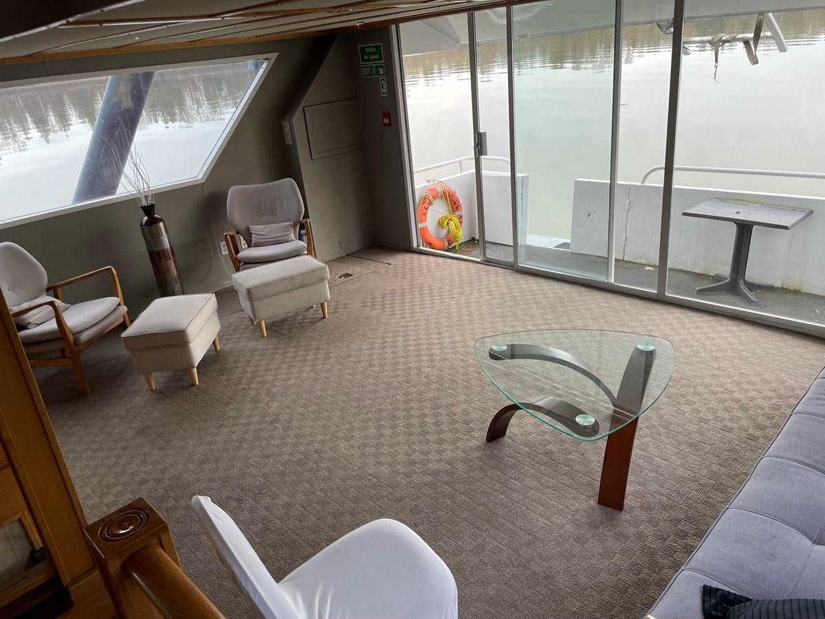 a room with chairs and tables aboard MAGIC MOMENT Yacht for Sale