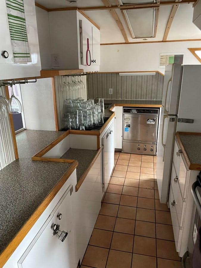 a kitchen with white cabinets aboard MAGIC MOMENT Yacht for Sale