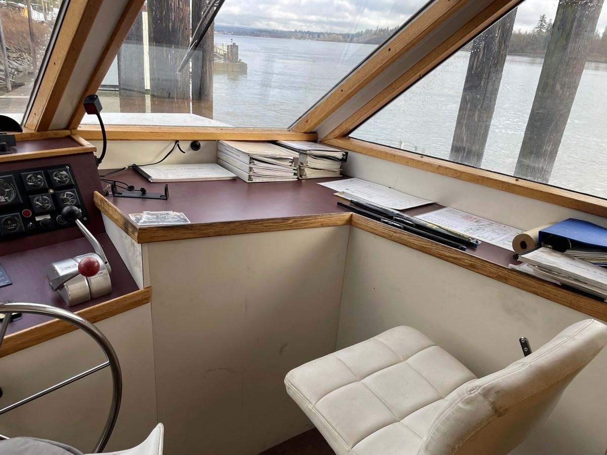 a desk with a chair and a window aboard MAGIC MOMENT Yacht for Sale