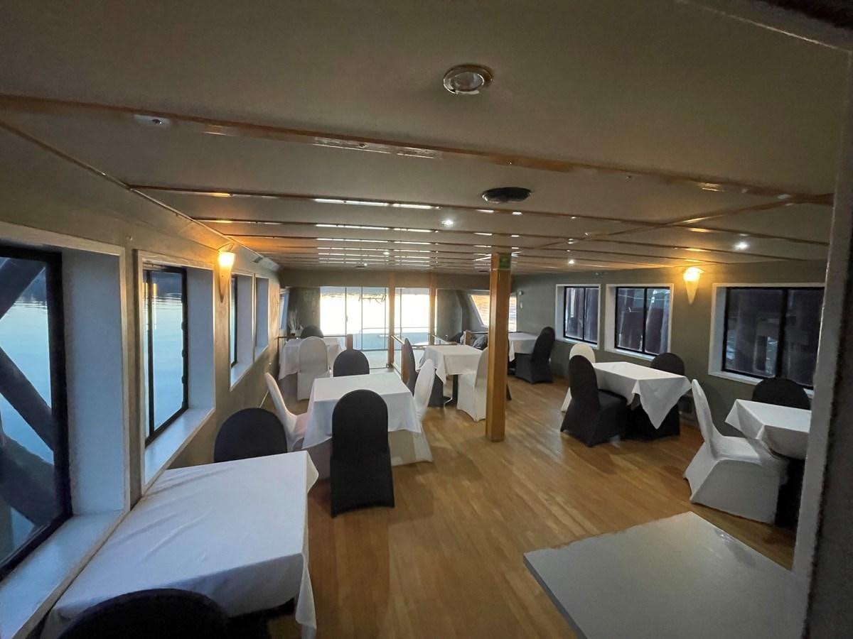 a room with a large table and chairs aboard MAGIC MOMENT Yacht for Sale