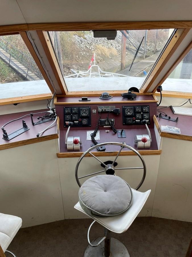 a room with a chair and a table and a window aboard MAGIC MOMENT Yacht for Sale
