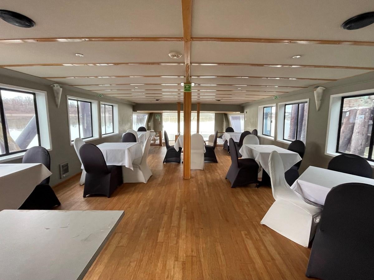a room with a wood floor and white chairs and a wood floor aboard MAGIC MOMENT Yacht for Sale