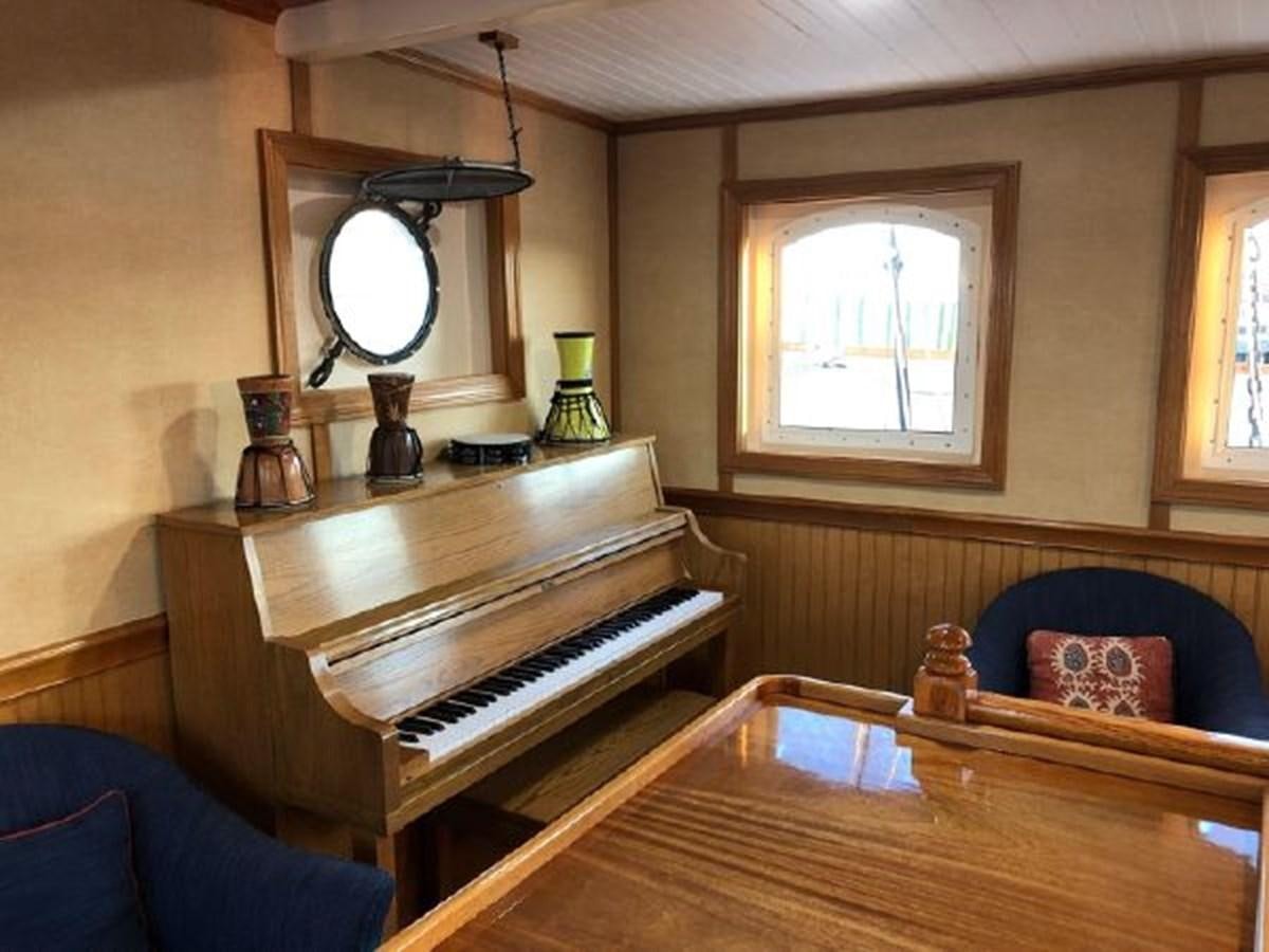 a room with a piano and a mirror aboard MYSTIC Yacht for Sale