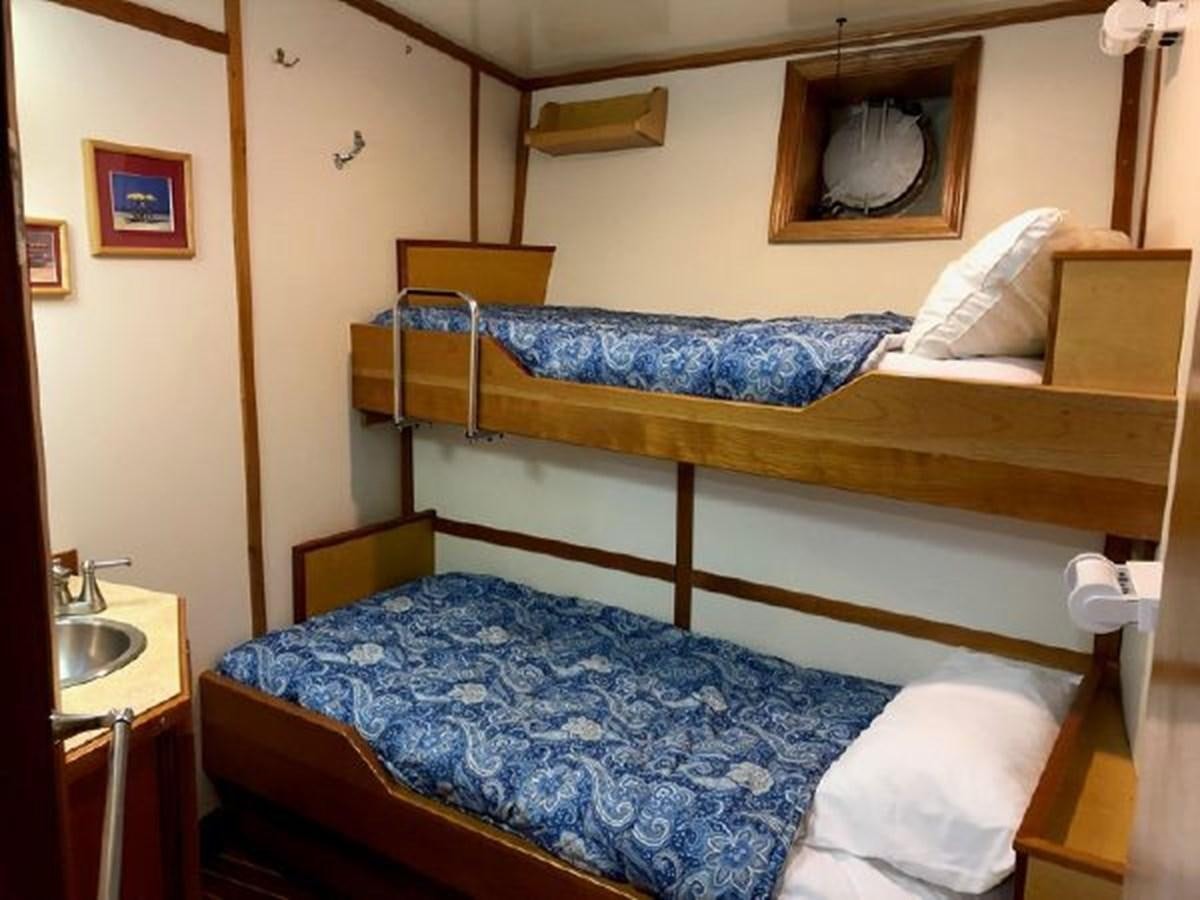 a bed with a blue comforter aboard MYSTIC Yacht for Sale