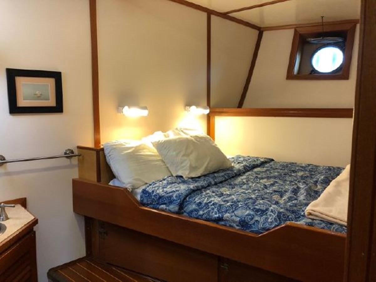 a bed with a blue comforter aboard MYSTIC Yacht for Sale