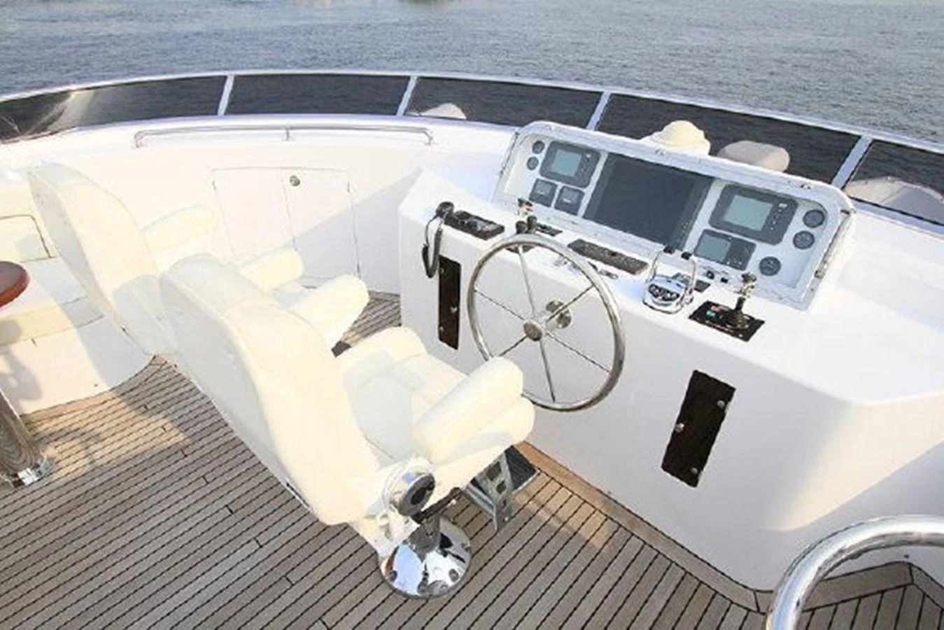 a white boat with a steering wheel aboard WHITE LOTUS Yacht for Sale