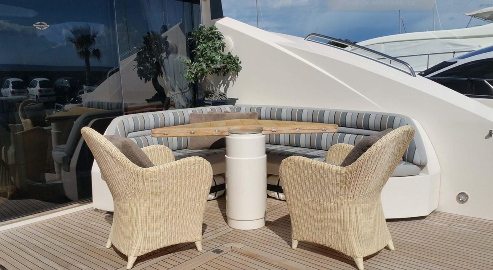 a table with chairs and a surfboard on it aboard VA VA VROOM Yacht for Sale