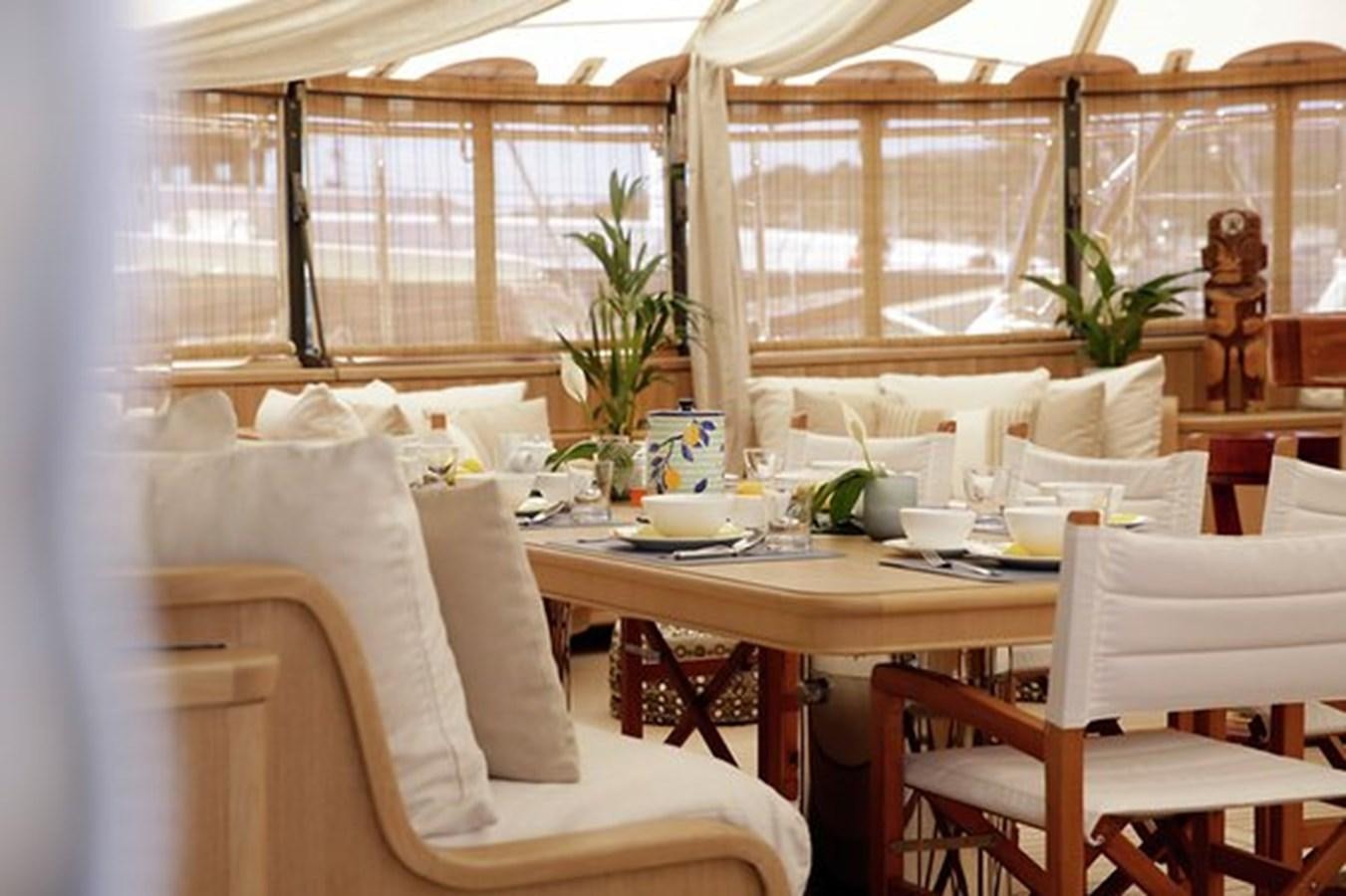 a table with chairs and plants aboard LA LUNA Yacht for Sale
