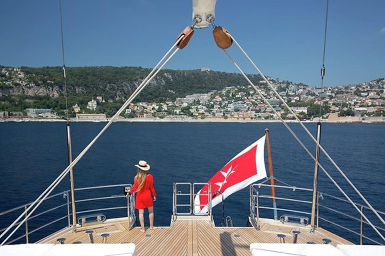 a person standing on a boat with a flag aboard LA LUNA Yacht for Sale