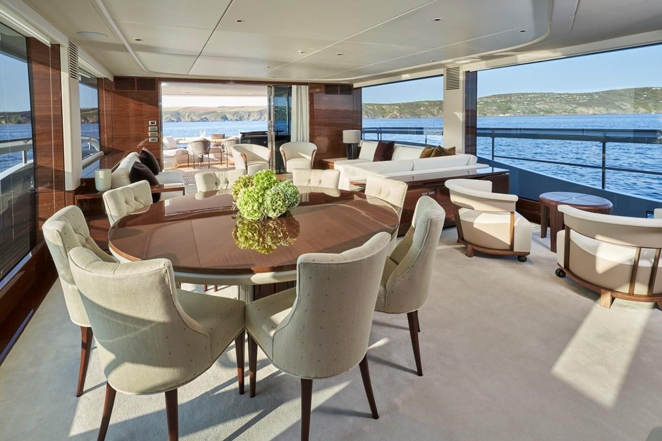 a room with tables and chairs aboard ROVAL Yacht for Sale