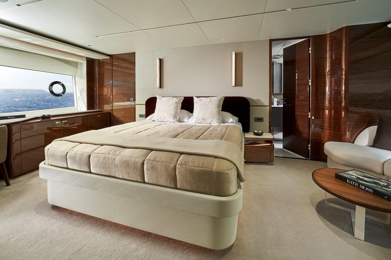 a bedroom with a bed and a desk aboard ROVAL Yacht for Sale