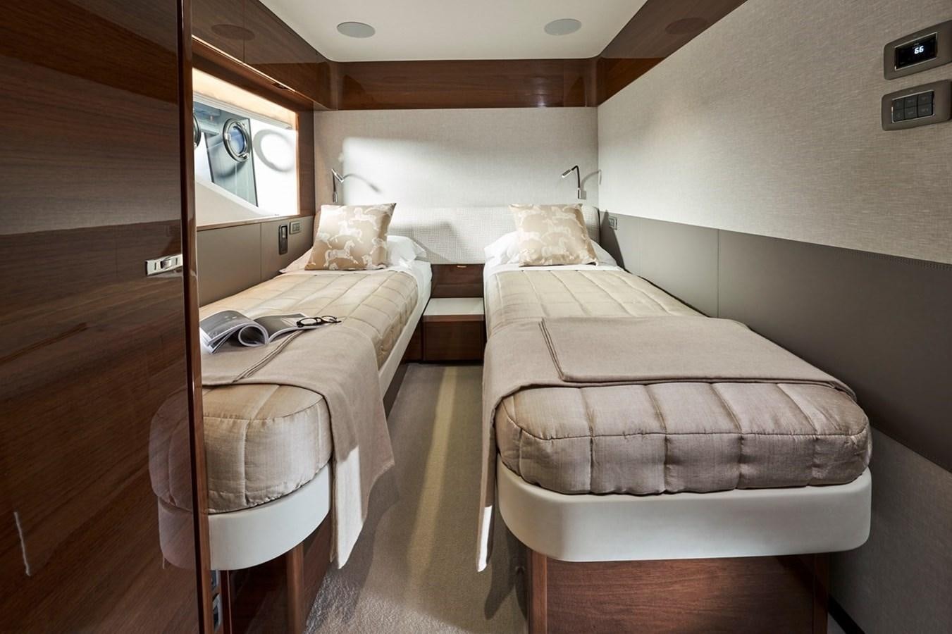 a room with beds and a television aboard ROVAL Yacht for Sale