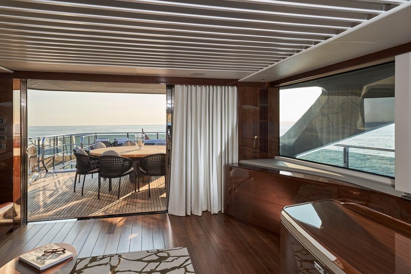 a room with a table chairs and a large window aboard ROVAL Yacht for Sale