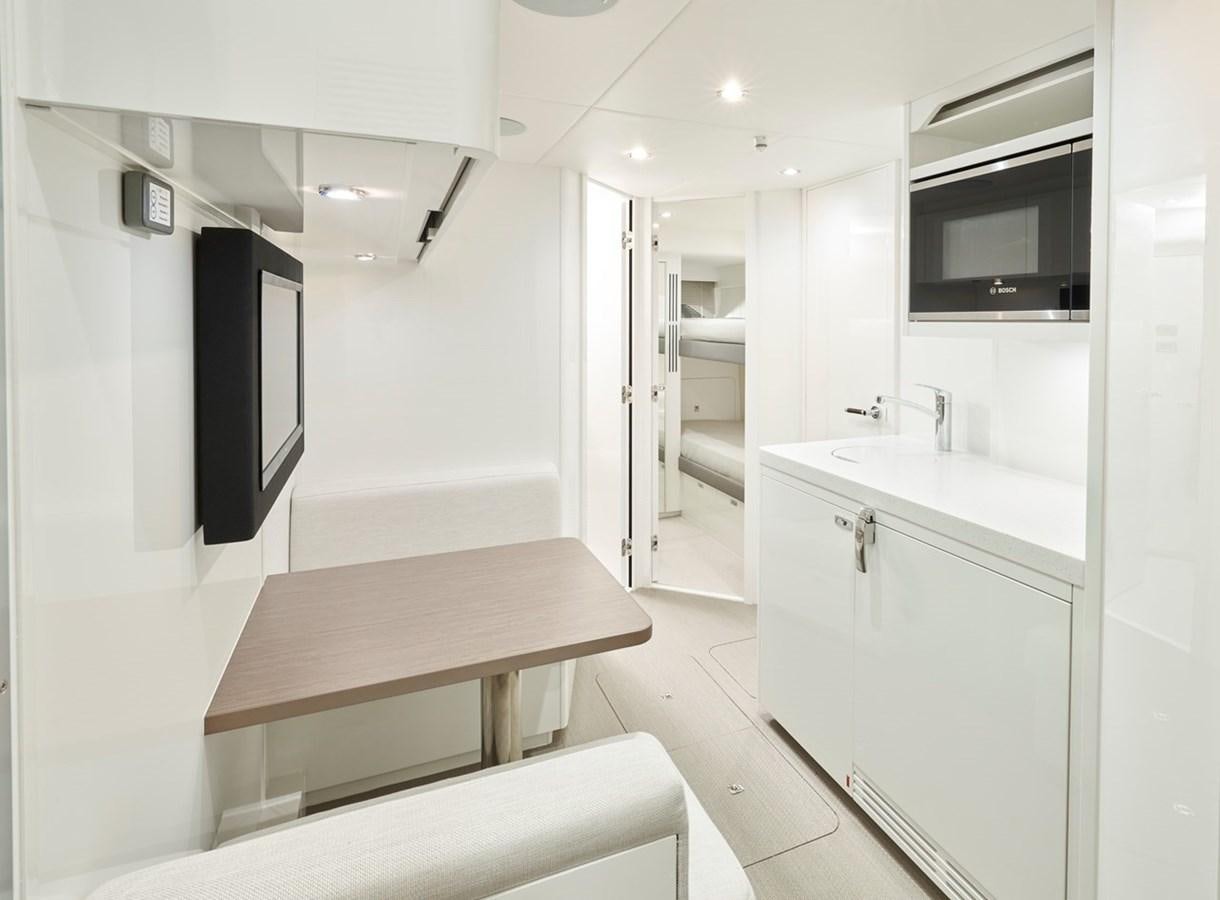 a room with a table and tv aboard ROVAL Yacht for Sale